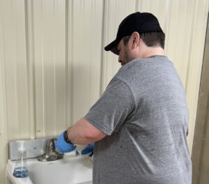 A member of USET's Lead Reduction Team takes a sample of water from a faucet.